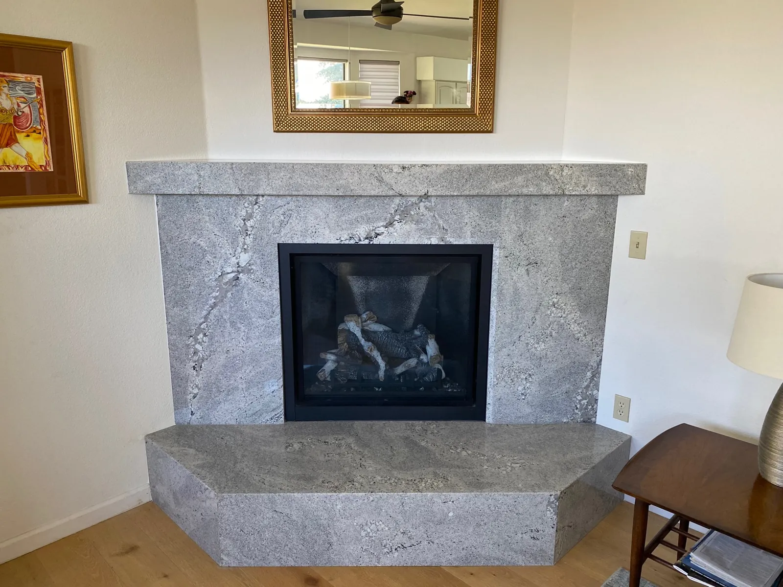 Polished granite fireplace mantel and raised hearth with beveled detailing in a Carson City living room