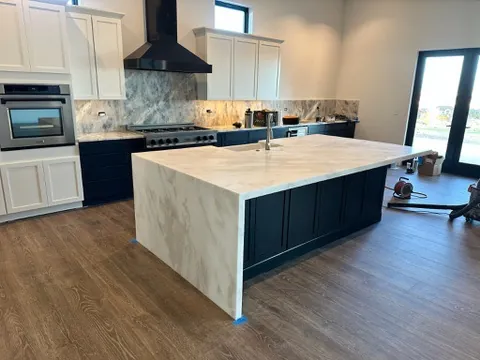 Honed White Rhino dolomite waterfall island with a mitered edge and farmhouse sink in a Genoa, Nevada kitchen