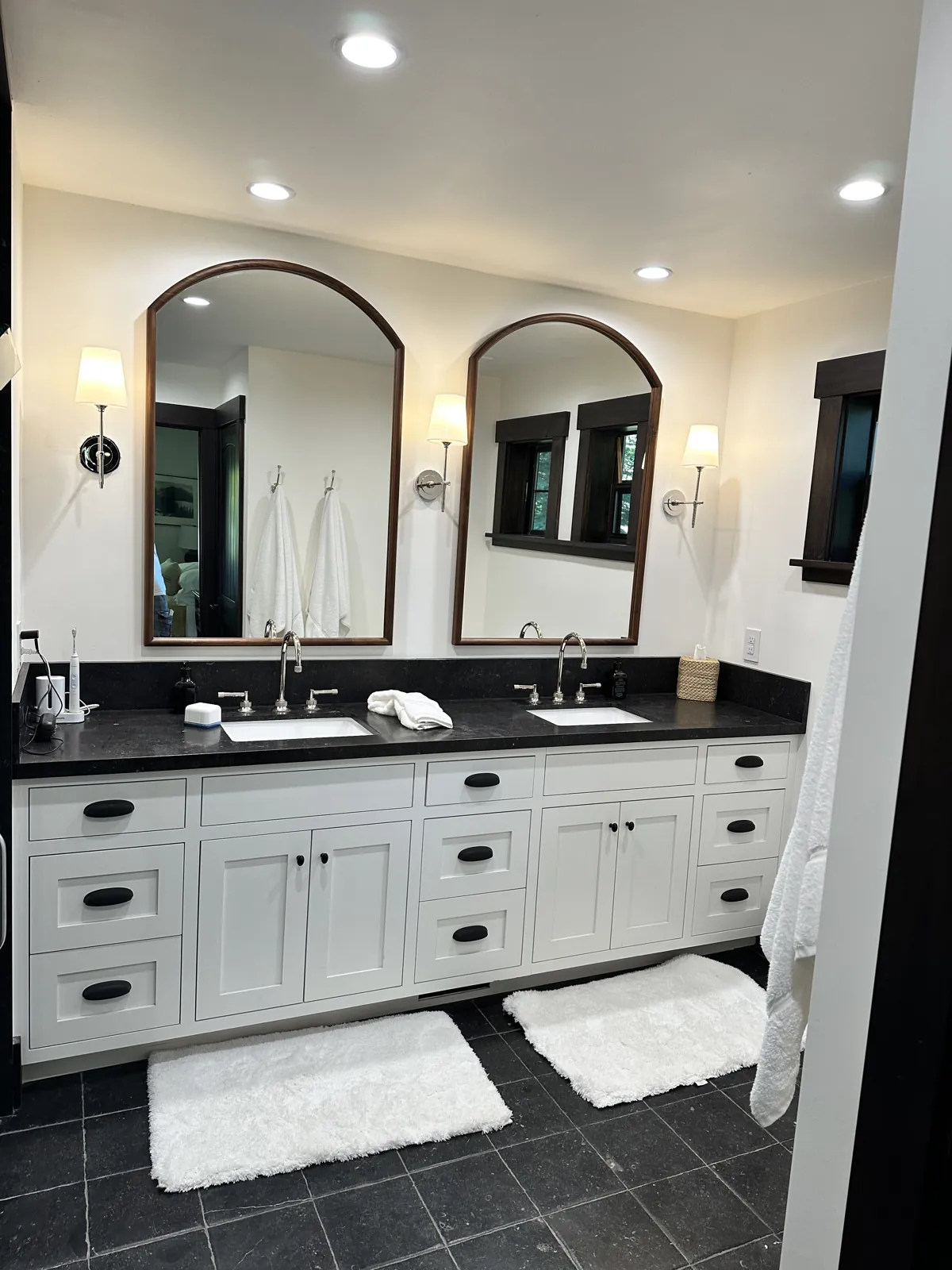 Black limestone double vanity countertop with undermount sinks and a 6-inch backsplash in a Lake Tahoe primary bath