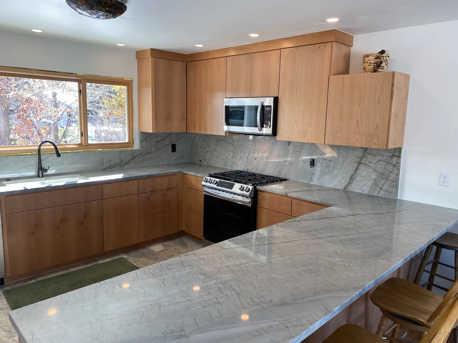 Polished quartzite countertops with a full-height backsplash and stone windowsill in a new Lake Tahoe kitchen