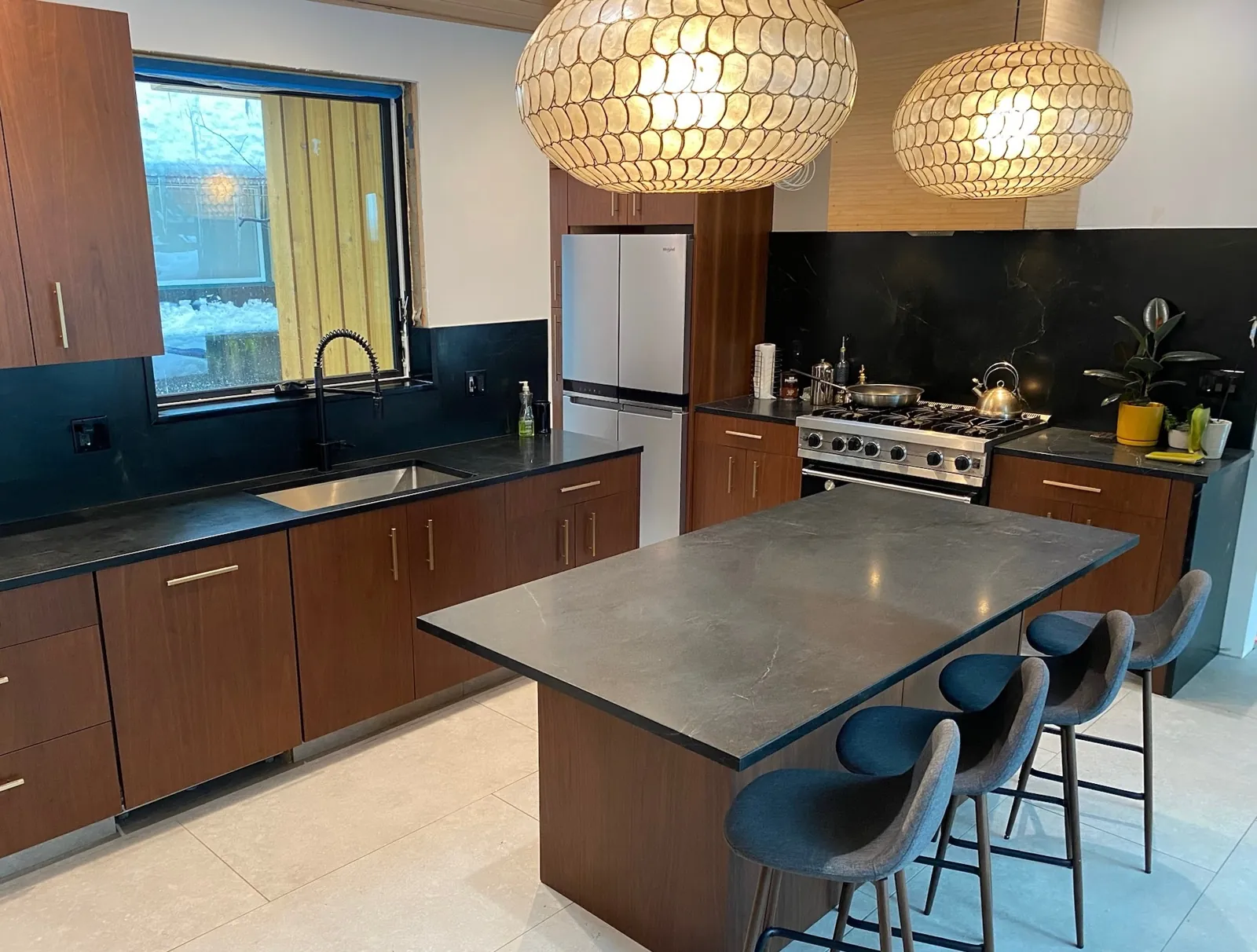Soapstone countertops and island with a tall soapstone backsplash under the range hood in a Lake Tahoe kitchen